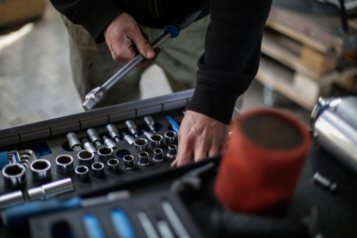 Selecting sockets from an organized kit gives storage context, not a demonstration of the shortlisted organizers.